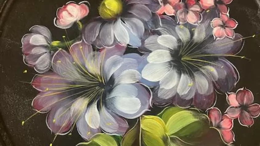 black background with flowers painted in muted blues, purples and pinks