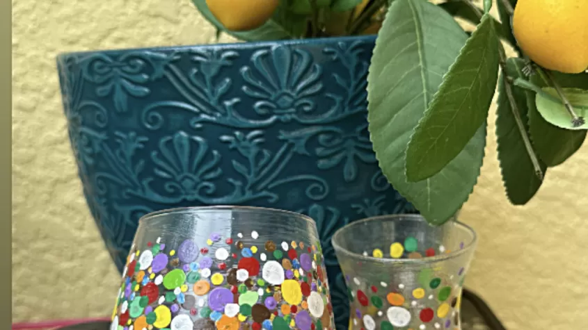 picture of someone holding a multi color painted wine glass